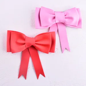 Detailed view of pink and red double-layer EVA foam bows for cake decoration and parties.