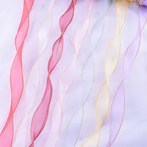 Vista dettagliata di nastri in organza multicolore con eleganti bordi oro ondulati.