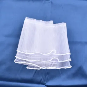 Detail shot of white pleated tulle cake border decoration with elegant wavy edges