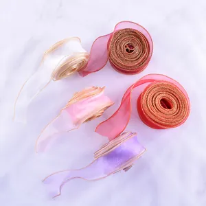 Dettaglio di nastri colorati in filato a coda di pesce con eleganti bordi dorati per confezioni