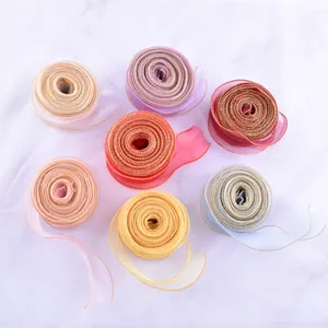 Dettaglio di nastri in organza multicolore con eleganti bordi in filo dorato decorativo.