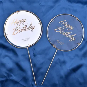 Close-up detail of elegant golden Happy Birthday cake toppers on blue satin background