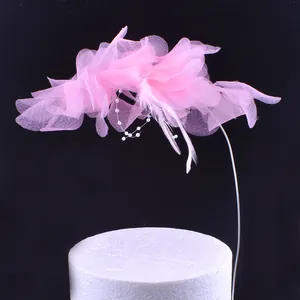 Rosa Tüllblumen-Kuchendeko mit edlen Perlen und Federn für schöne Geburtstags-Torten.