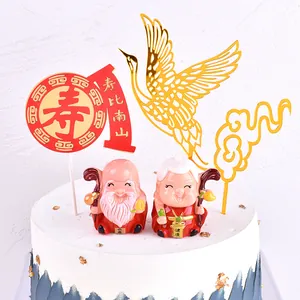 Detailed view of golden acrylic crane and auspicious cloud cake toppers for longevity celebration