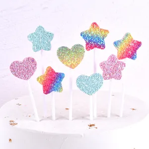 Macro detail of colorful glitter heart and star-shaped cake toppers on white cake