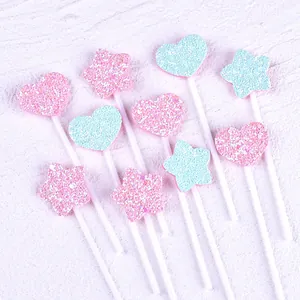Detail of glittery pink and blue heart and star cake toppers with fabric texture