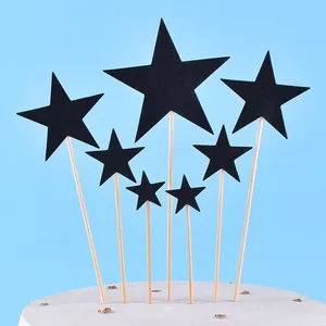 Close-up detail of black glitter star shaped cake toppers with wooden sticks for party decoration