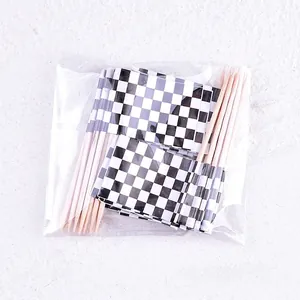 Detailed view of 24pcs black and white checkered racing flag cake toppers in packaging.