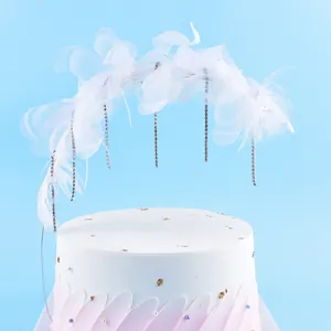 Gros plan sur une décoration de gâteau en arche de plumes blanches avec strass