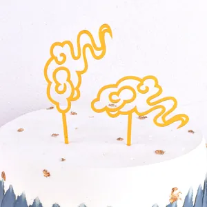 Detail view of golden acrylic auspicious cloud cake toppers for festive baking