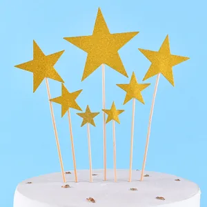 Detailed view of seven gold glitter star cake toppers on sticks for party desserts