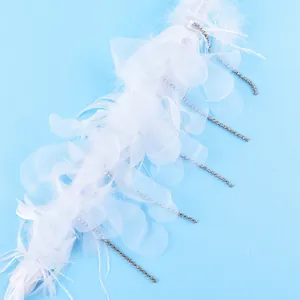 Gros plan sur un gâteau en plumes blanches avec pétales en organza et strass brillants
