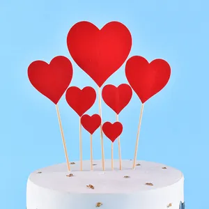 Detailed view of multiple red heart cake toppers in various sizes on a white cake