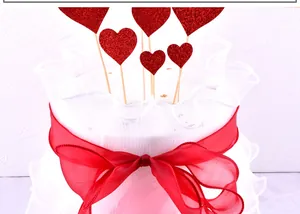 Detail view of glittery red heart cake toppers and elegant red mesh ribbon border decoration