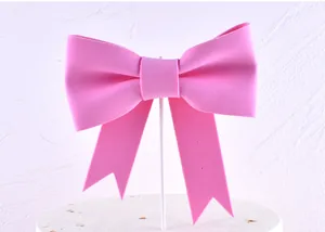 Detailed view of a large pink foam bow cake topper used for birthday party decorations