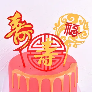 Detailed view of gold acrylic Fu and Shou traditional cake toppers on a pink frosted cake