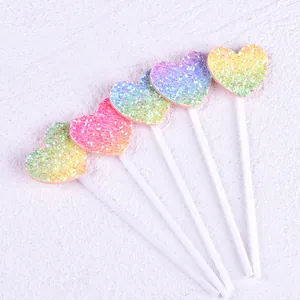Detailed macro view of 5-piece set of gradient rainbow glitter heart cake toppers