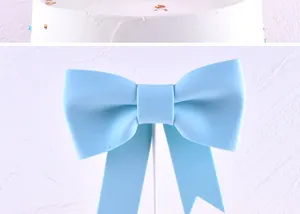 Close-up of light blue bow cake topper with elegant matte finish for decoration.