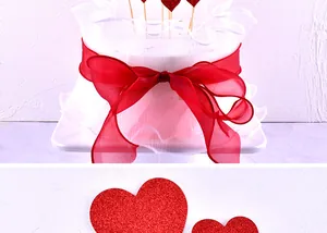 Close-up of red glitter heart cake toppers and sheer ribbon for Valentine's Day decoration