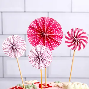 Decorative set of four pink and white patterned paper fan cake toppers for party decor
