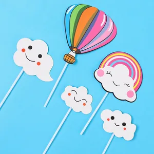 Close-up of cute rainbow hot air balloon and smiling cloud cake toppers party set