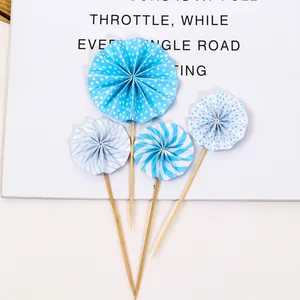 Detail of blue and white striped paper fan cake toppers on wooden sticks