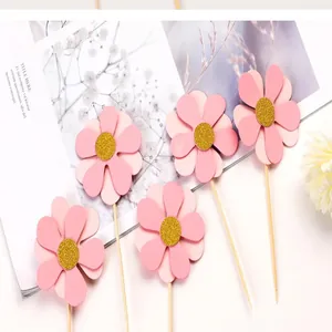 Gros plan de décorations de gâteau tournesol rose à double couche et à paillettes dorées