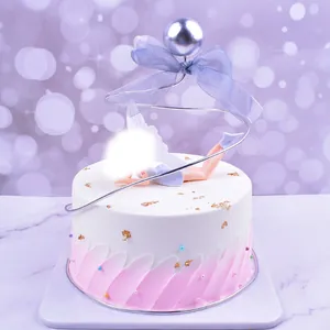Detailed view of an elegant spiral iron cake topper with a purple bow and fairy.