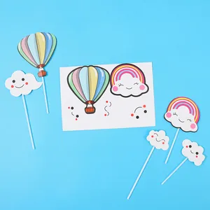 Detail view of colorful rainbow and hot air balloon cake toppers on a blue background