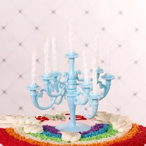 Detail view of light blue vintage plastic candelabra cake topper with white candles.