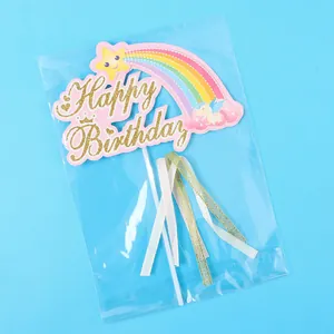 Detailansicht eines Regenbogen-Happy-Birthday-Kuchenaufsatzes mit Goldglitzer und Schleifen