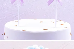 Detailansicht der fliederfarbenen Schleifen und Pastell-Pompons für Kuchendekoration.