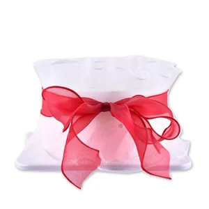 Elegant white mesh cake border decoration featuring a large red organza ribbon bow