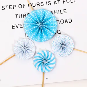 Detailed view of four blue pleated paper fan cake toppers featuring dot and stripe patterns