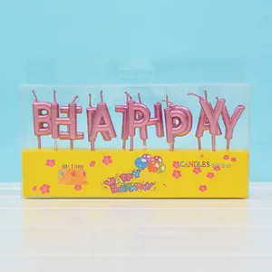 Nahaufnahme von metallisch rosa Happy Birthday Kerzen in einer gelben Verpackung