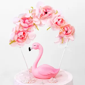 Detailed macro view of a pink flamingo cake topper with an elegant rose flower arch