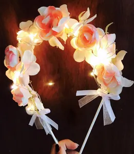 Close-up of pink rose floral arch cake topper with warm LED lights and ribbons