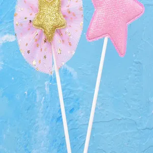 Vista detallada de adornos para tarta con estrellas de purpurina rosa y dorada y encaje