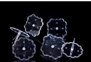 Close-up of clear plastic flower-shaped bases for cake toppers and figurines