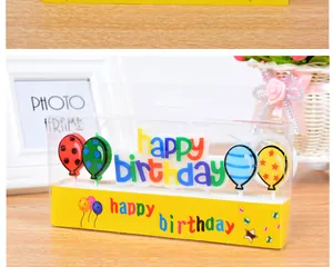 Close-up of colorful 'Happy Birthday' letter and balloon candle set in transparent box