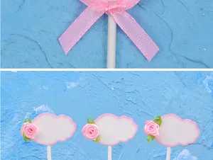 Close-up of pink DIY cloud cake toppers with fabric rose and ribbon bow details