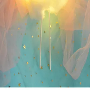 Close-up of a glowing white 3D cloud cake topper for birthday party decorations.
