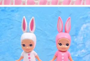 Close-up detail of two cute mini doll cake toppers with white and pink rabbit hats