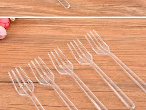 Close-up detail of transparent disposable plastic four-prong forks for dessert and fruit