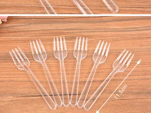Detailed view of 11.5cm transparent plastic disposable fruit forks on wood surface