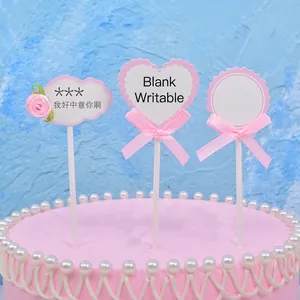 Heart-shaped DIY writable cake toppers with pink bows for birthday decoration