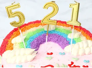 Velas doradas número 521 de alta calidad en un pastel de cumpleaños de arco iris