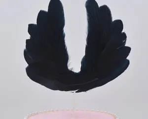 Macro detail of black feather wing cake topper for birthday and wedding party decor