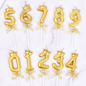 Decorative golden number birthday candles with crowns and bows for cake topper set