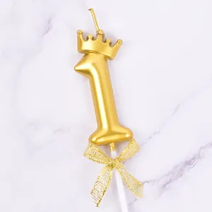Detailed view of a golden number 1 birthday candle with a crown and mesh bow tie